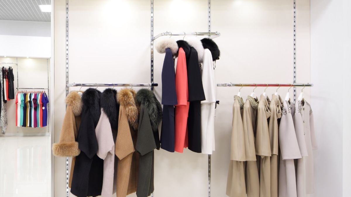 Abrigos elegantes colgados en tienda de ropa