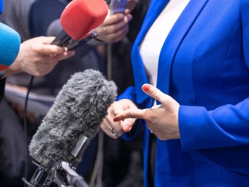 Persona respondiendo preguntas ante varios micrófonos