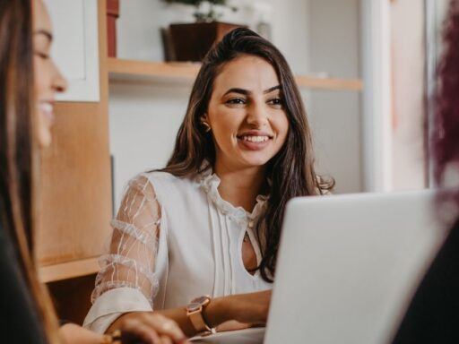 Mujer trabajando sonriente frente al ordenador portátil