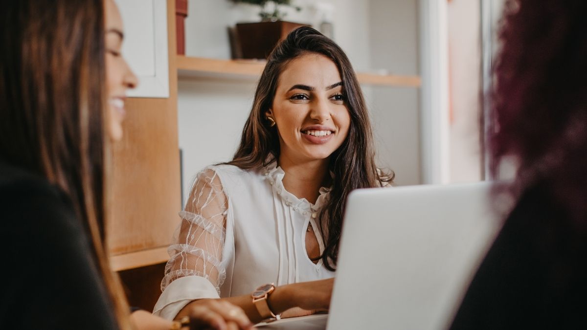 Mujer trabajando sonriente frente al ordenador portátil