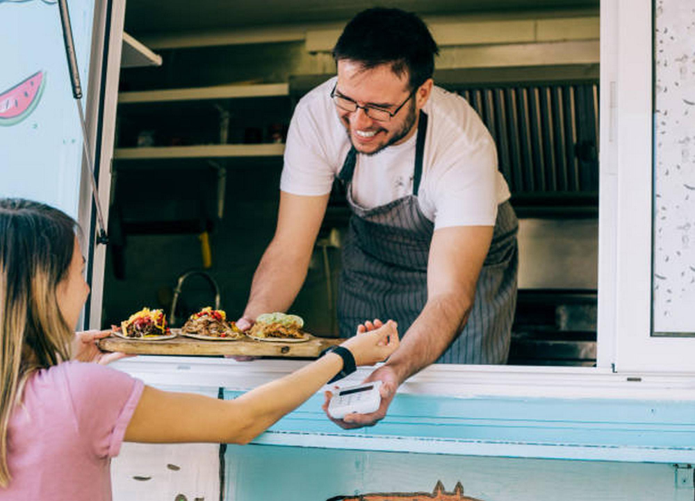 Vendedor sirve comida en camión restaurante