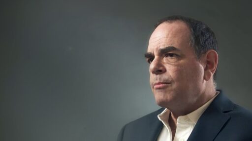 Hombre con traje mirando pensativo hacia la derecha