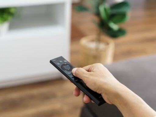 Persona usando mando a distancia en el salón