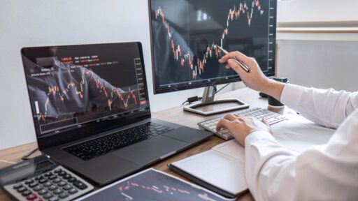 Analista financiero revisando gráficos bursátiles en ordenador