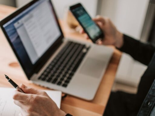 Persona trabajando con portátil y móvil en escritorio