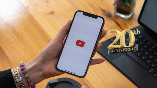 Persona sosteniendo móvil con logo de YouTube 20 aniversario