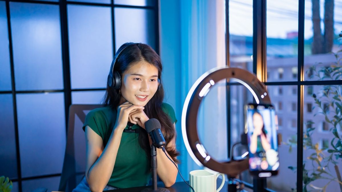 Mujer grabando pódcast con micrófono y auriculares