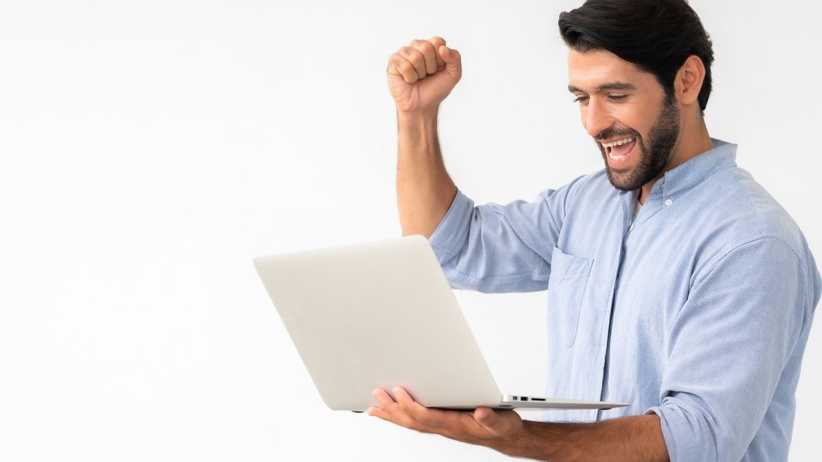 Hombre feliz celebrando frente al portátil