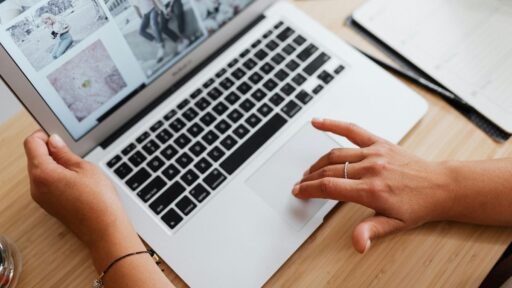 Persona usando laptop sobre escritorio de madera