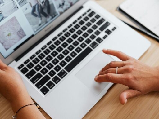 Persona usando laptop sobre escritorio de madera