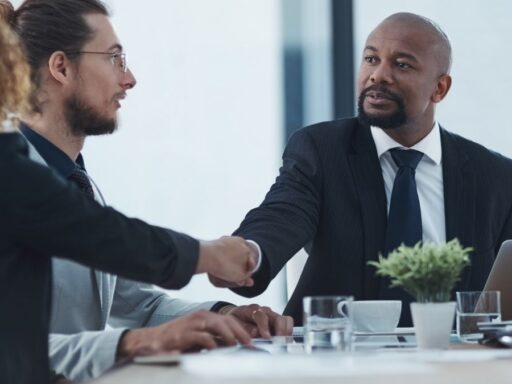 Personas de negocios dándose la mano en reunión