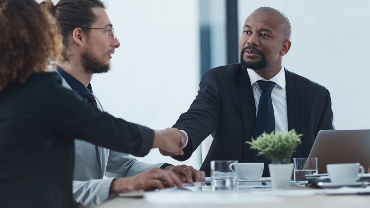 Personas de negocios dándose la mano en reunión