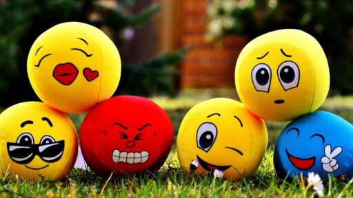 Pelotas con caritas de emojis en el césped