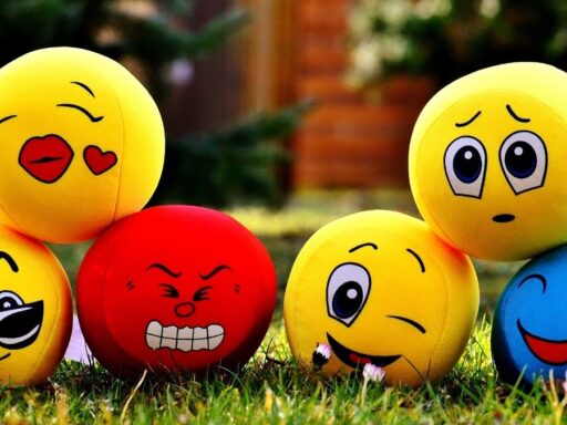Pelotas con caritas de emojis en el césped