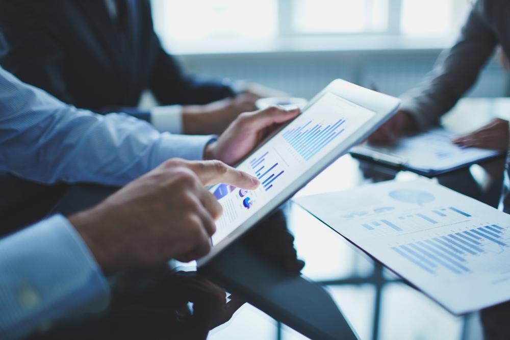 Personas analizando gráficos financieros en una tableta
