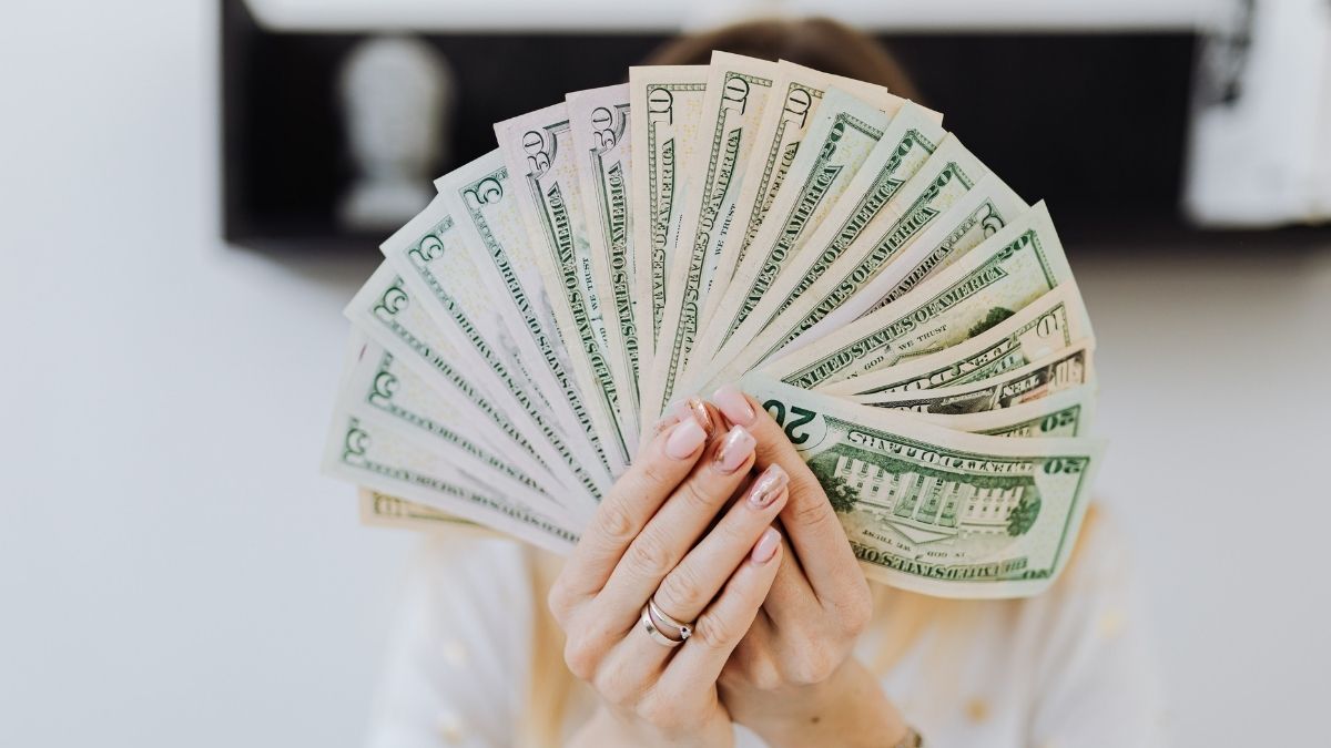 Persona sosteniendo billetes de dólares estadounidenses