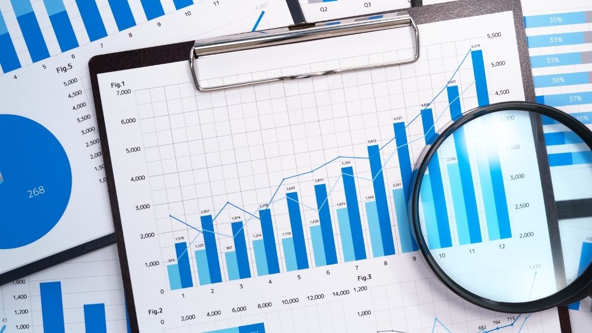 Gráficas financieras y lupa sobre informes económicos
